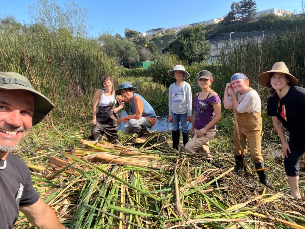 a group of seven people pose for a photo while taking a break in clean-up work at the alemany farm pond